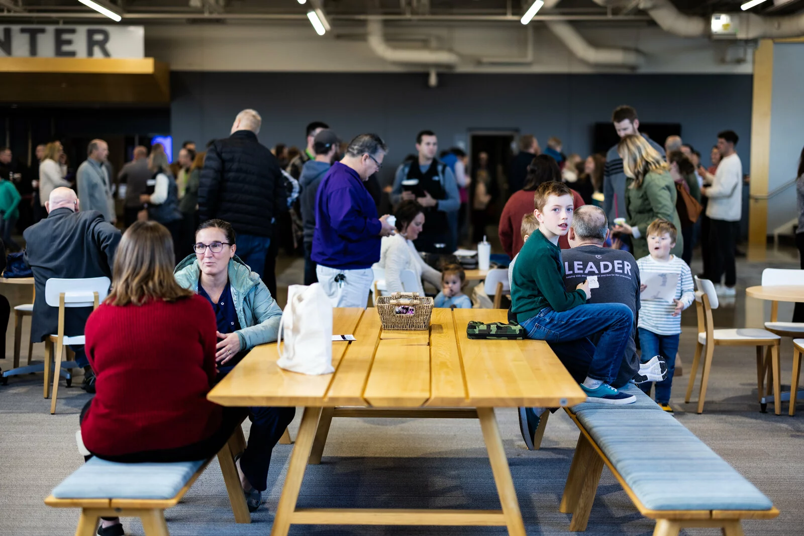 Moms and kids sitting at an indoor picnic table